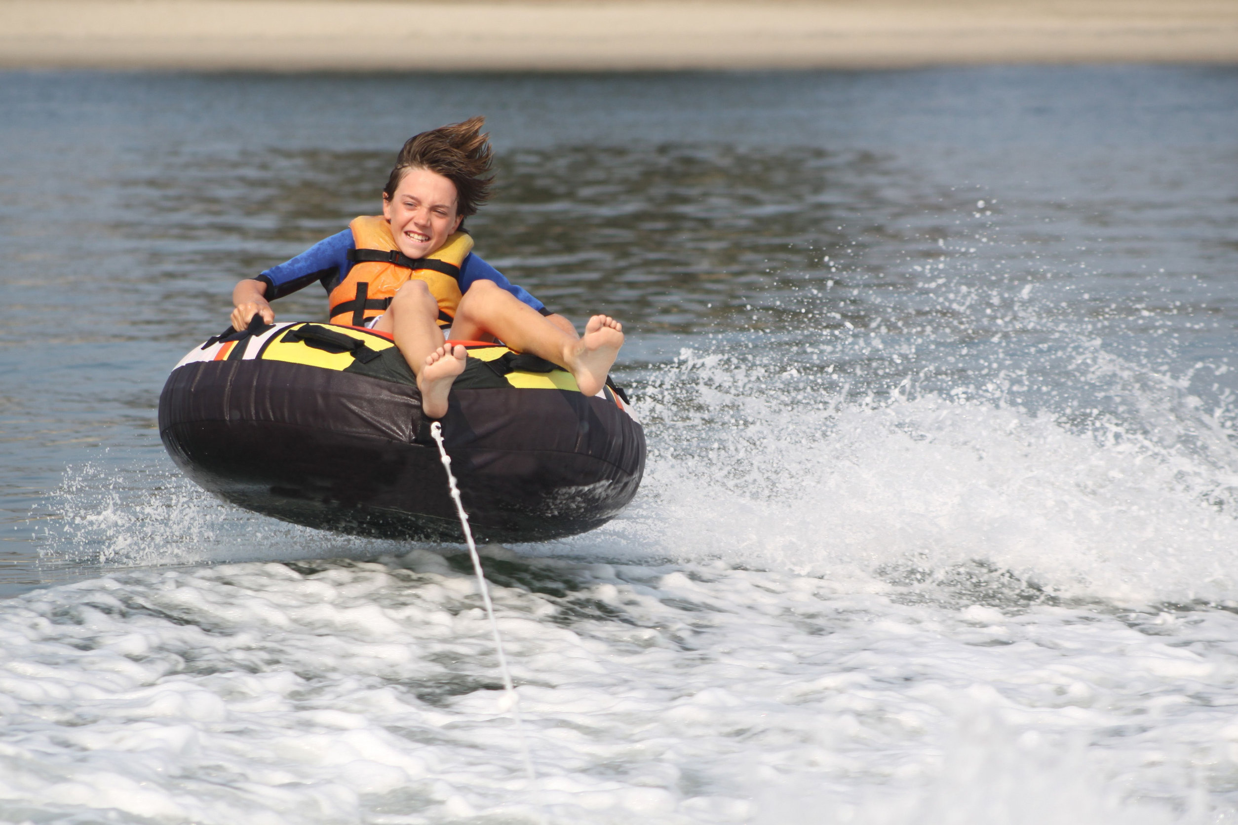 Boy on inner tube pulled by a boat